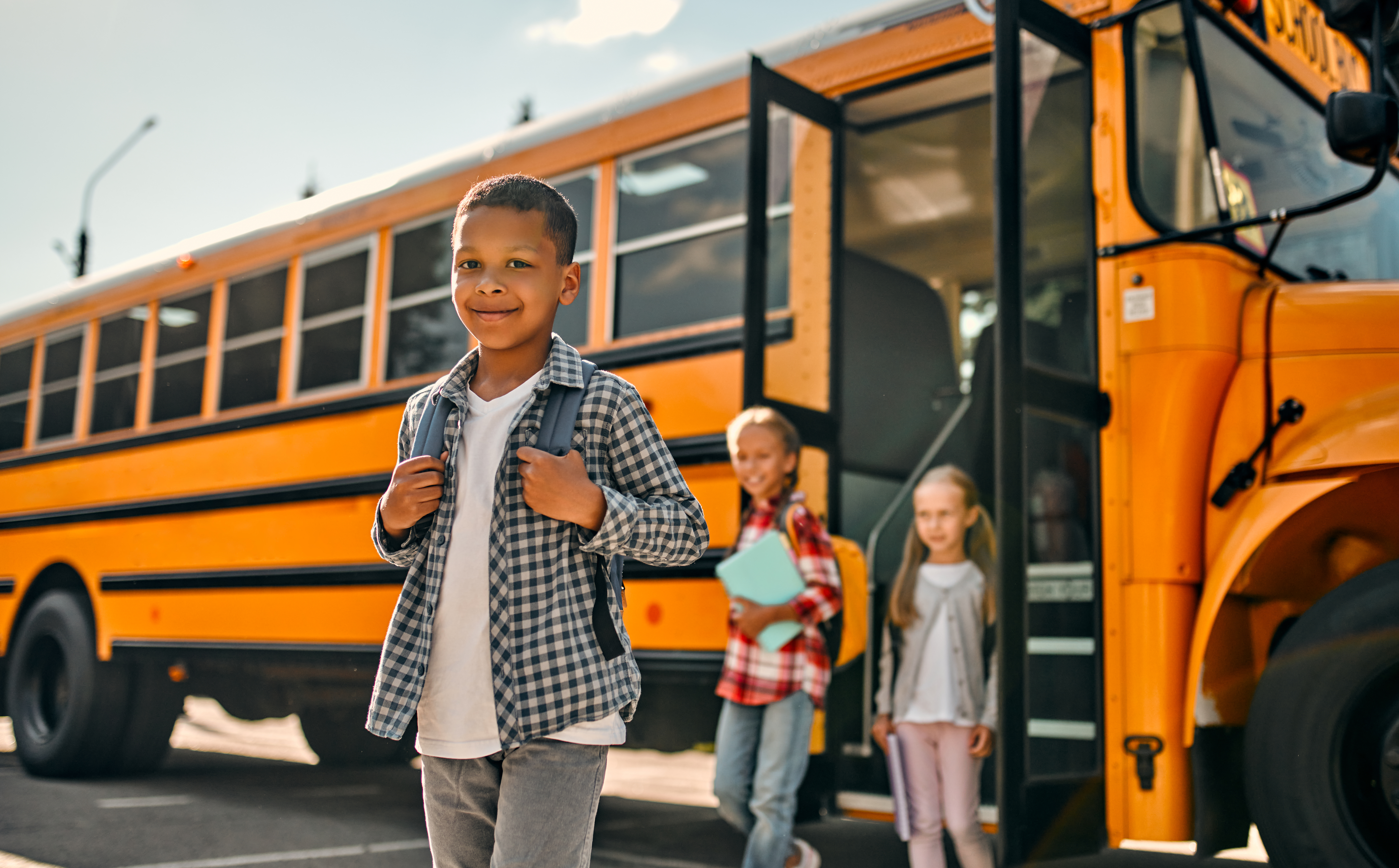 Children near / exiting a school bus. The cover photo for our 2024 CT-NSGP grant Guide